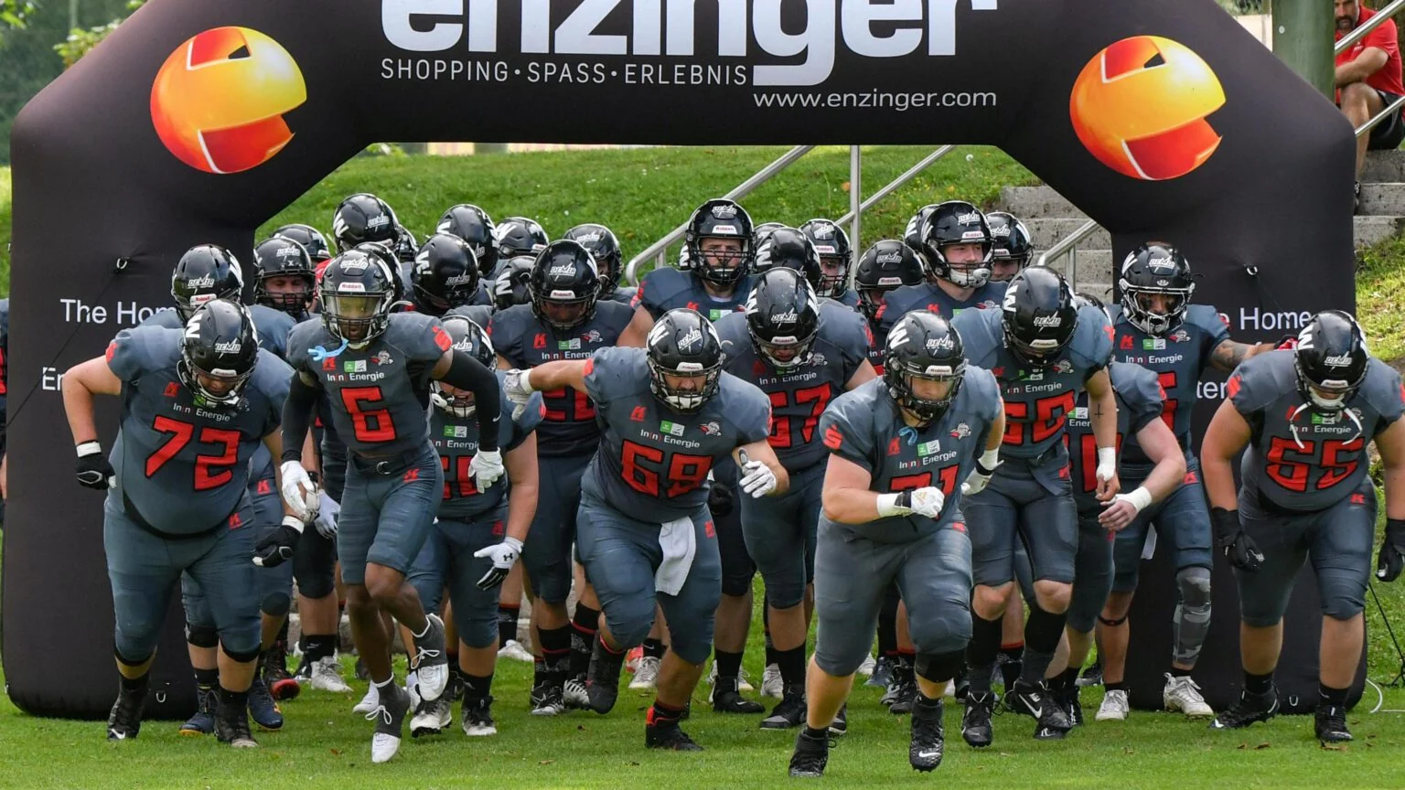 Die Kirchdorf Wildcats laufen gemeinsam durch den Torbogen auf das Spielfeld
